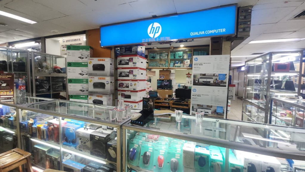Bagian dalam toko Qualiva Computer dengan etalase perangkat IT